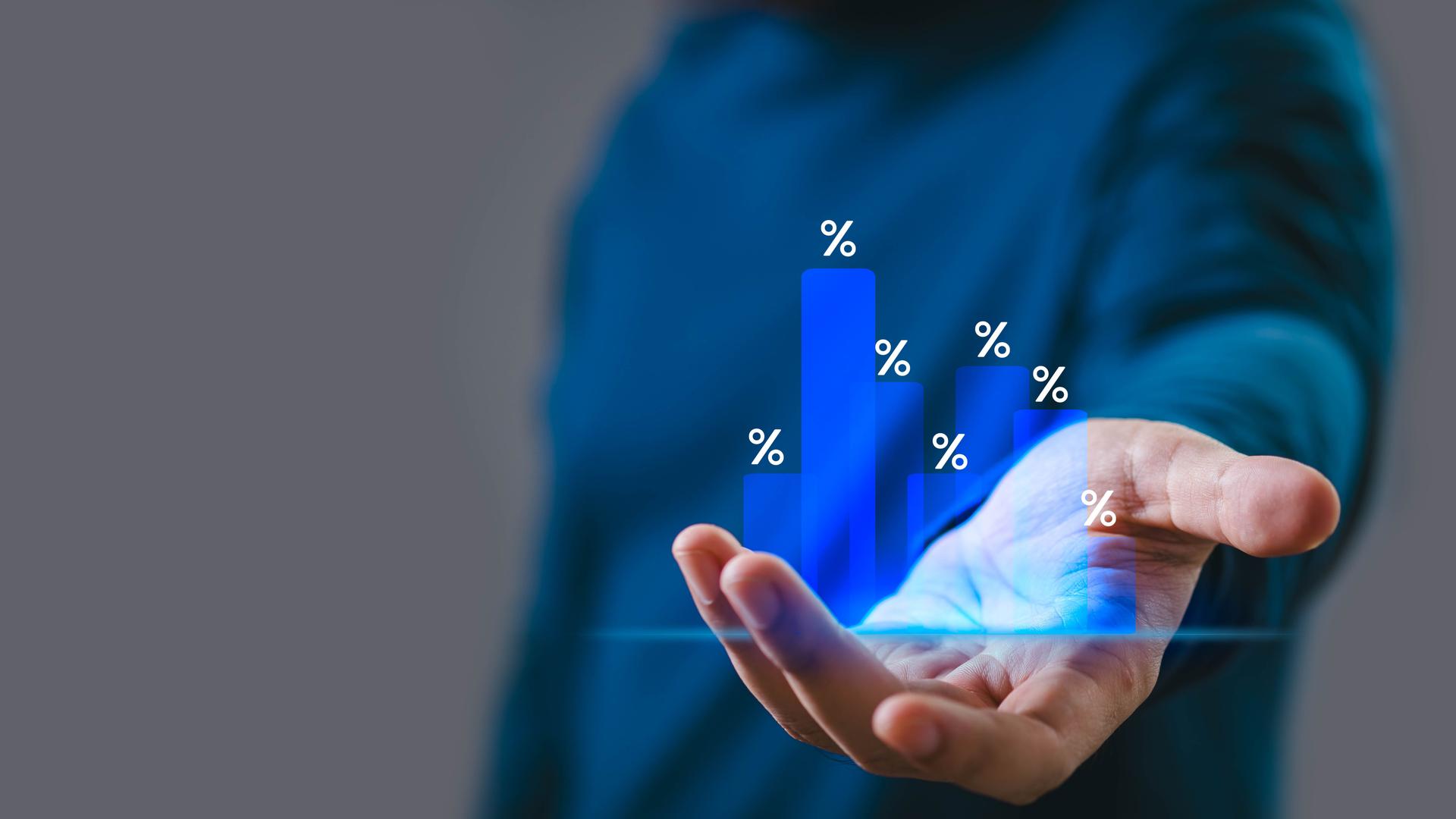 Close-up of a person holding a holographic bar chart with percentages, representing growth and data analysis. Business and finance concept.