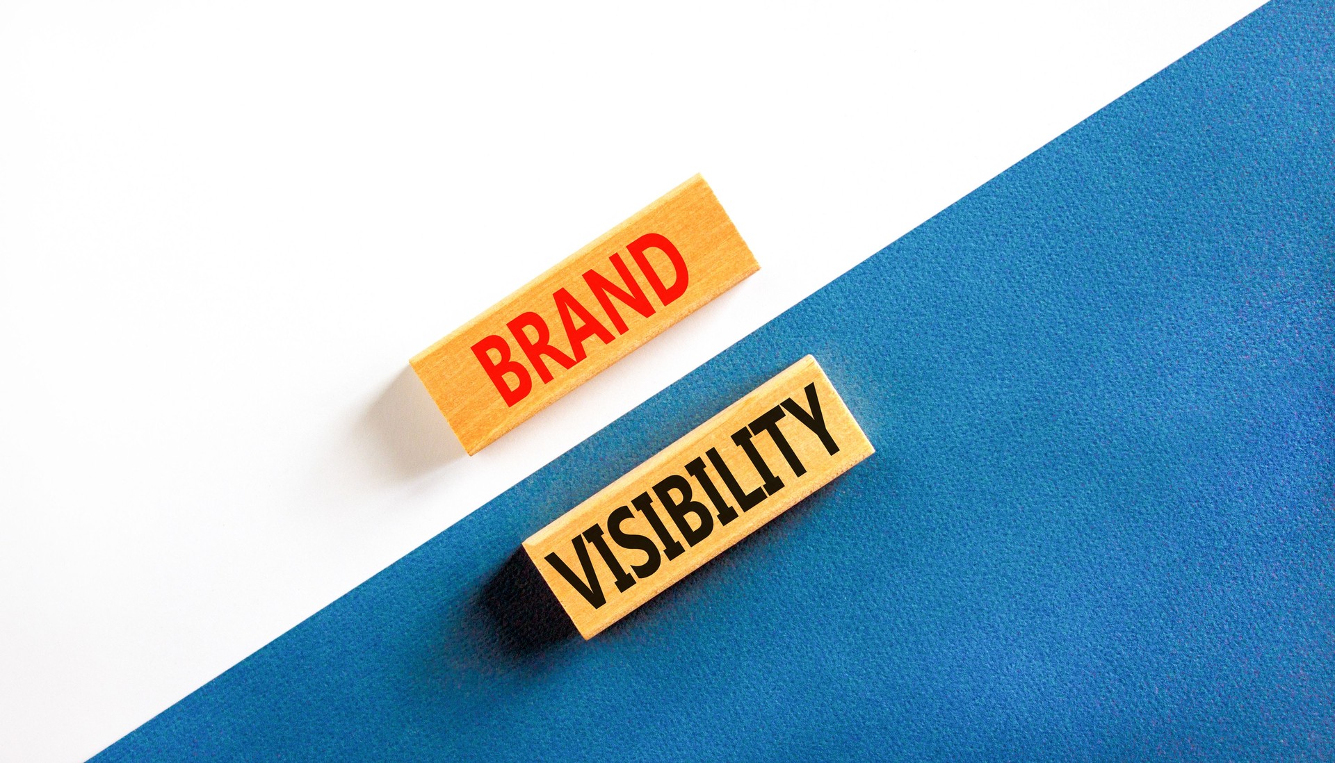 Brand visibility symbol. Concept words Brand visibility on wooden blocks. Beautiful white and blue background. Business branding and brand visibility concept. Copy space.